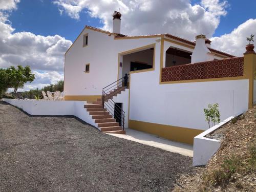 a white house with a staircase in front of it at Quinta Monte da Azinheira in Amareleja