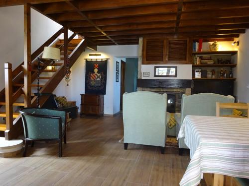 a room with a table and chairs and a staircase at Casa dos Relvas in Godigana