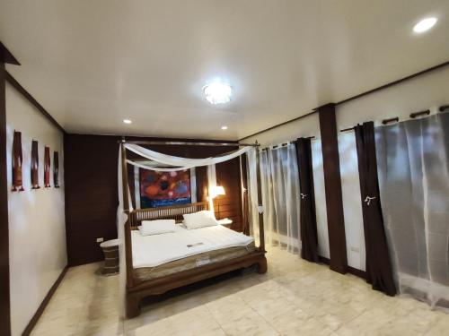 a bedroom with a canopy bed in a room at Banhom Pool villa บ้านหอมพูลวิลล่า in Ban Tha Ton Thong