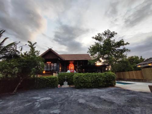 a house with a sign in front of it at Banhom Pool villa บ้านหอมพูลวิลล่า in Ban Tha Ton Thong