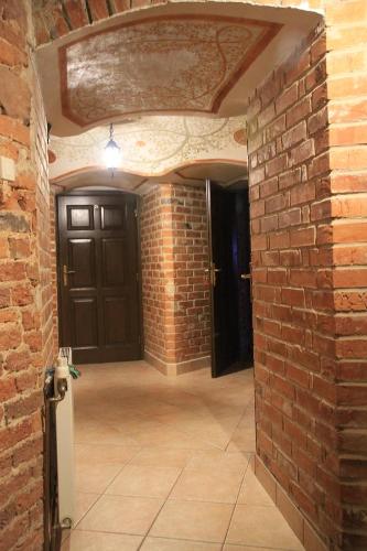 a brick hallway with a door and a brick wall at Dom pod Twierdzą Srebrna Góra in Srebrna Góra