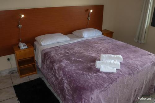 a bed with two rolls of toilet paper on it at Hotel Vila Rica Flat in Resende