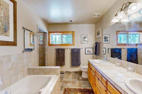 a bathroom with two sinks and a tub and a toilet at Modern Mountain Home in Kings Beach