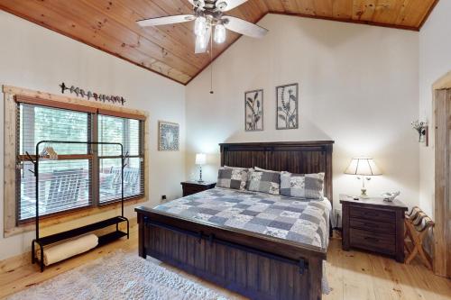 a bedroom with a bed and a ceiling fan at Rustic Ridge Cabin in Young Harris