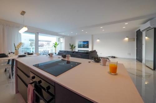 a kitchen and living room with a counter with a drink on it at Luxury brand new holiday apartments TOP location in Is-Swieqi
