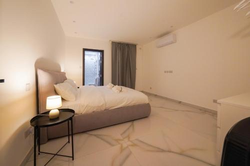 a bedroom with a bed and a table in it at Luxury brand new holiday apartments TOP location in Is-Swieqi