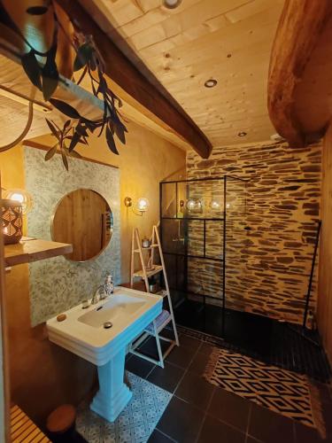 La salle de bains est pourvue d'un lavabo et d'un plafond en bois. dans l'établissement ar prad kirvi, à Rosquelfen