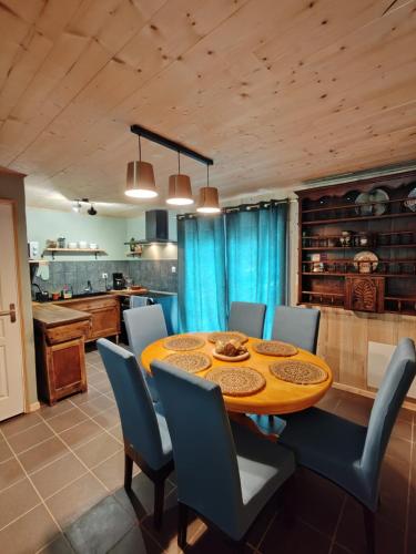 une salle à manger avec une table en bois et des chaises bleues dans l'établissement ar prad kirvi, à Rosquelfen