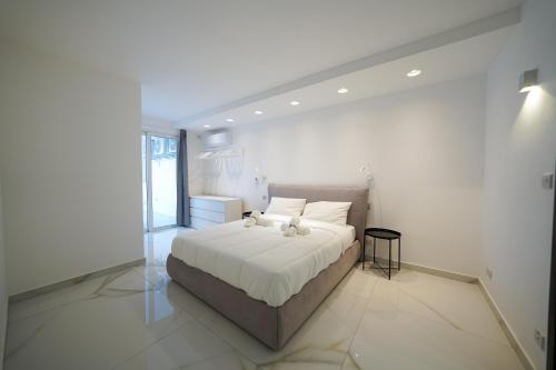 a bedroom with a white bed with a teddy bear on it at Luxury brand new holiday apartments TOP location in Is-Swieqi