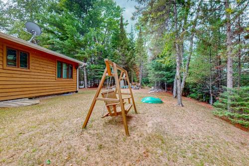 a wooden swing set in front of a cabin at Konkey's Kabin in Saint Germain