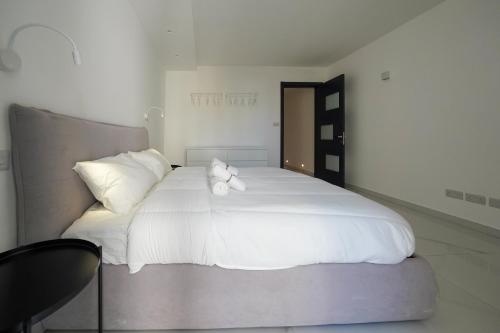 a large white bed with a teddy bear on it at Luxury brand new holiday apartments TOP location in Is-Swieqi