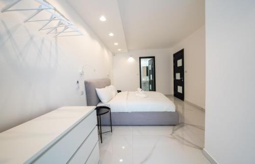a white bedroom with a bed and a window at Luxury brand new holiday apartments TOP location in Is-Swieqi