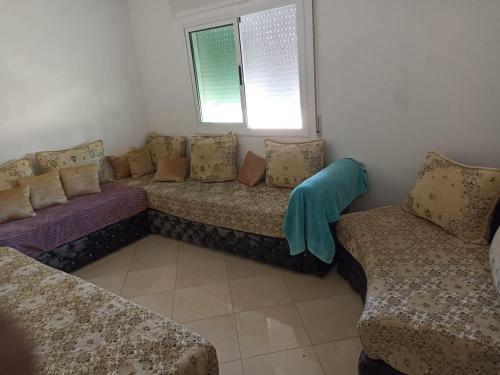 una sala de estar con un sofá y dos sillas en Oued laou, en Oued Laou