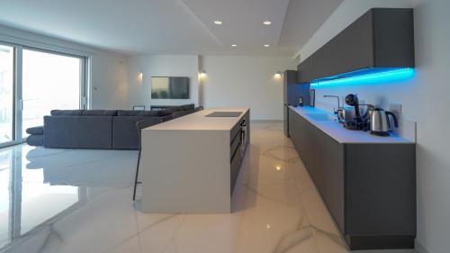 a kitchen and living room with a couch in the background at Luxury brand new holiday apartments TOP location in Is-Swieqi