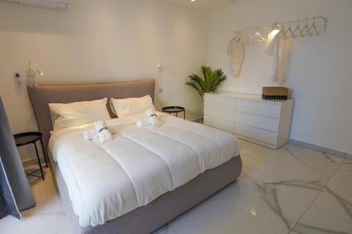 a bedroom with a large bed with white sheets at Luxury brand new holiday apartments TOP location in Is-Swieqi