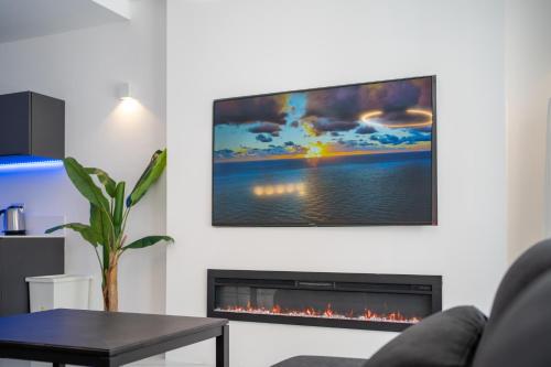 a living room with a fireplace with a flat screen tv at Luxury brand new holiday apartments TOP location in Is-Swieqi