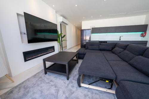 a living room with a large couch and a tv at Luxury brand new holiday apartments TOP location in Is-Swieqi