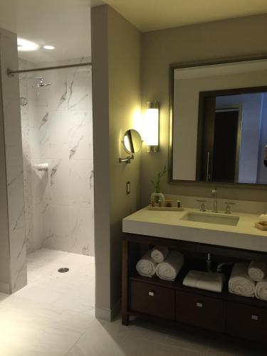 a bathroom with a sink and a mirror and a shower at Parkwest Bicycle Casino in Bell Gardens