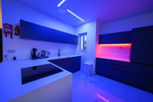 a kitchen with blue and purple lights in a kitchen at Luxury brand new holiday apartments TOP location in Is-Swieqi