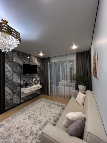 Una sala de estar con un sofá y un televisor. en Квартира на Тимирязева 58 Luxury Central, en Almaty