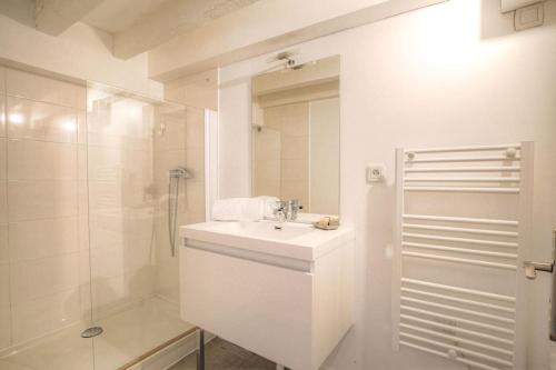 une salle de bain blanche avec un lavabo et une douche dans l'établissement Appartement spacieux, proche gare, Lyon 3e, à Lyon