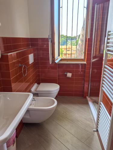 a bathroom with a toilet and a sink and a window at Residence Dei Fiori in Pietra Ligure