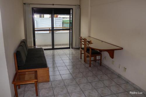 a room with a table and a chair and a desk at Hotel Vila Rica Flat in Resende