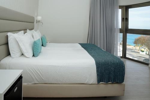 a bedroom with a bed and a large window at Carvi Beach Hotel in Lagos