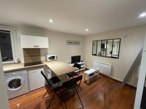 une cuisine avec une table et des chaises dans une pièce dans l'établissement Charmant studio en plein cœur de Chambéry, à Chambéry