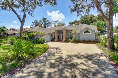 a house with a driveway and trees at Screened Lanai and Fenced Yard Luxe Orlando Home in Orlando