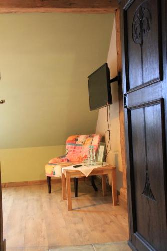 a room with a chair and a table and a tv at Dom pod Twierdzą Srebrna Góra in Srebrna Góra