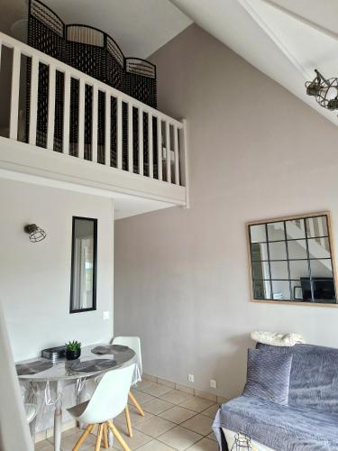 un salon avec une table et un lit dans l'établissement Appartement Balcon Centre Cabourg, à Cabourg