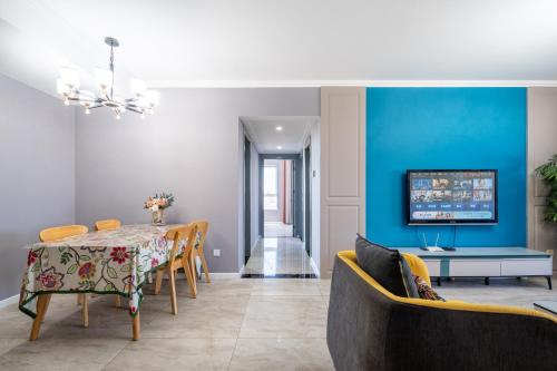 a dining room with a table and a blue wall at Cloud & Sea Boutique Apartment in Rizhao