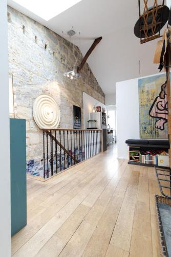 Il comprend un salon doté de parquet et d'un mur en briques. dans l'établissement Loft à Bordeaux, à Bordeaux