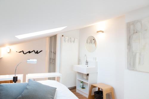 Cette chambre blanche dispose d'un lavabo et d'un lit. dans l'établissement Loft à Bordeaux, à Bordeaux