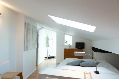- une chambre blanche avec un lit et une lampe dans l'établissement Loft à Bordeaux, à Bordeaux