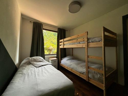 a bedroom with two bunk beds and a window at Huisje de Haeg in Ermelo