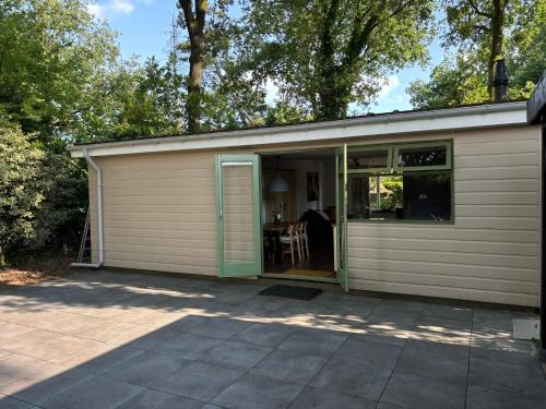 a garage with a door open and a patio at Huisje de Haeg in Ermelo