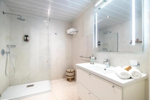 a white bathroom with a sink and a shower at Mangia's Pollina Resort in Cefalù