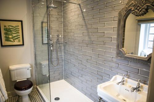 a bathroom with a shower and a sink and a toilet at Leeds Castle Stable Courtyard Bed and Breakfast in Maidstone