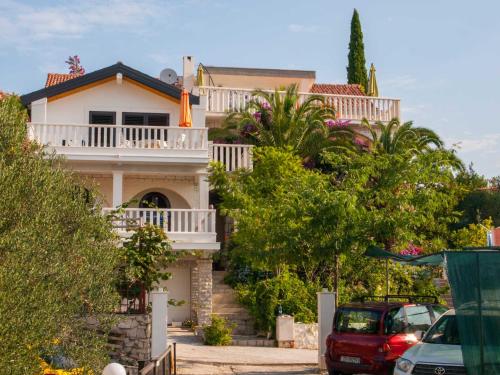 una casa en una colina con coches aparcados delante en Villa Clematis, en Trogir