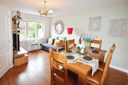 a dining room with a wooden table and chairs at Modern house near Glasgow 3bdr in Dalmuir