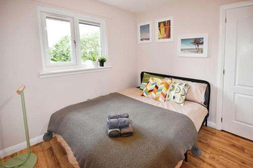 a small bedroom with a bed and a window at Modern house near Glasgow 3bdr in Dalmuir