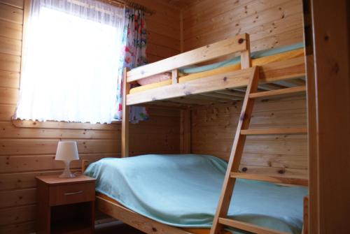 a bunk bed in a log cabin with a window at Mandarynka OW in Jarosławiec