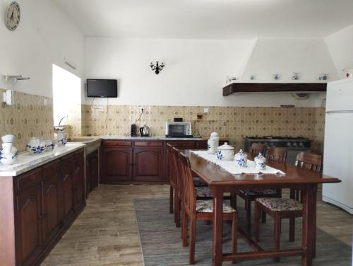 a kitchen with a table with chairs and a stove at Casa do Albano in Viana do Castelo