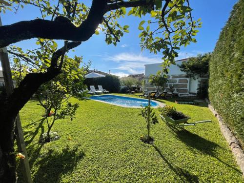 a backyard with a swimming pool and a grass yard at Casa do Albano in Viana do Castelo