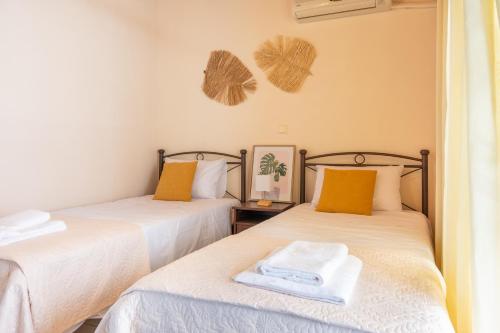 a room with two beds with towels on them at AQUA Apartment in Koroni