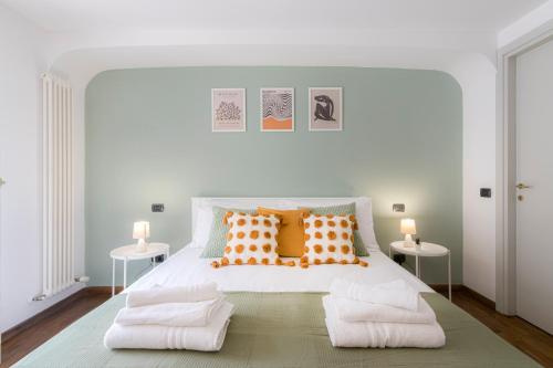 a bedroom with a white bed with orange pillows at DUOMO Relax in centro, WiFi, Aria Condizionata in Parma