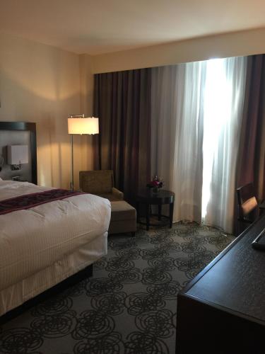 a hotel room with a bed and a chair at Parkwest Bicycle Casino in Bell Gardens