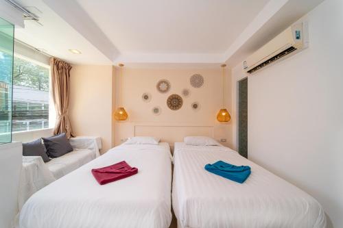 two beds in a room with red and blue towels at Catnip Seaside Hotel&Cafe in Ban Huai Luk (1)